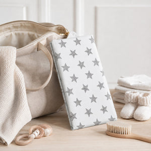 Compact foldable baby changing mat with monochrome stars. Wipe-clean padded surface, popper closure and practical size for changing bags and travel. UK