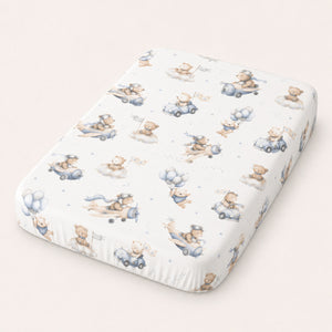 Close-up of blue teddy bear aviation fitted sheet with aeroplanes, cars, balloons and clouds for cot and cot bed mattresses