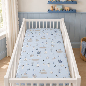 Pale blue woodland animals baby fitted sheet in a white cot, styled with blue nursery panelling and natural wood details