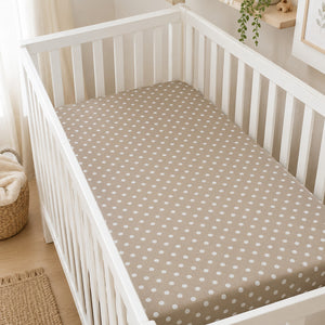 Close-up of beige and white polka dot cotton fabric used for Fabricco baby fitted sheets