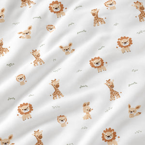 SnuzPod bedside crib with natural beige safari animals fitted sheet featuring lions, giraffes and fawns, handmade from 100% cotton for a neutral nursery.Fabricco