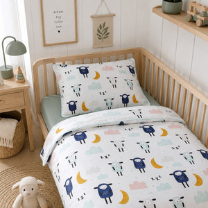 Soft Scandinavian baby bedding set with sleepy sheep print in a white cot bed, featuring pastel clouds and moon design in 100% cotton. UK