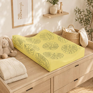 Soft ochre yellow leaf anti-roll baby changing mat in a Scandinavian-style nursery Fabricco