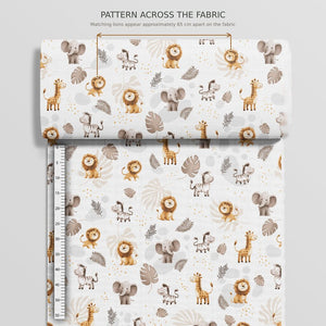 Rolled beige safari animals cotton fabric with a guide between matching lions, showing they appear approximately 65 cm apart across the fabric width.