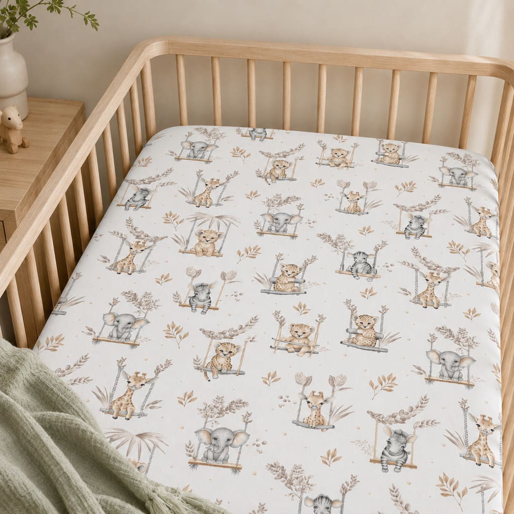 Close-up of beige safari cotton fitted sheet showing elephants, giraffes, zebras, lions and leafy nursery print
