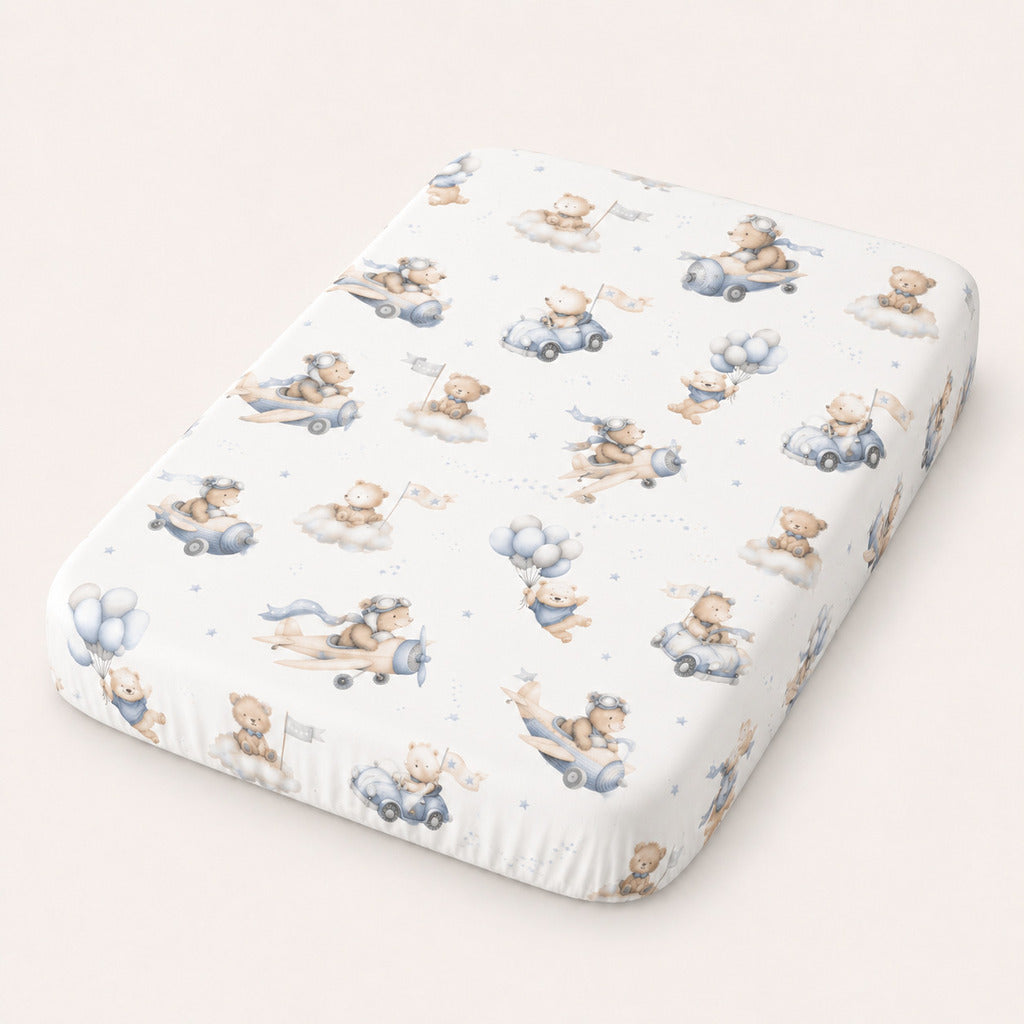 Close-up of blue teddy bear aviation fitted sheet with aeroplanes, cars, balloons and clouds for cot and cot bed mattresses