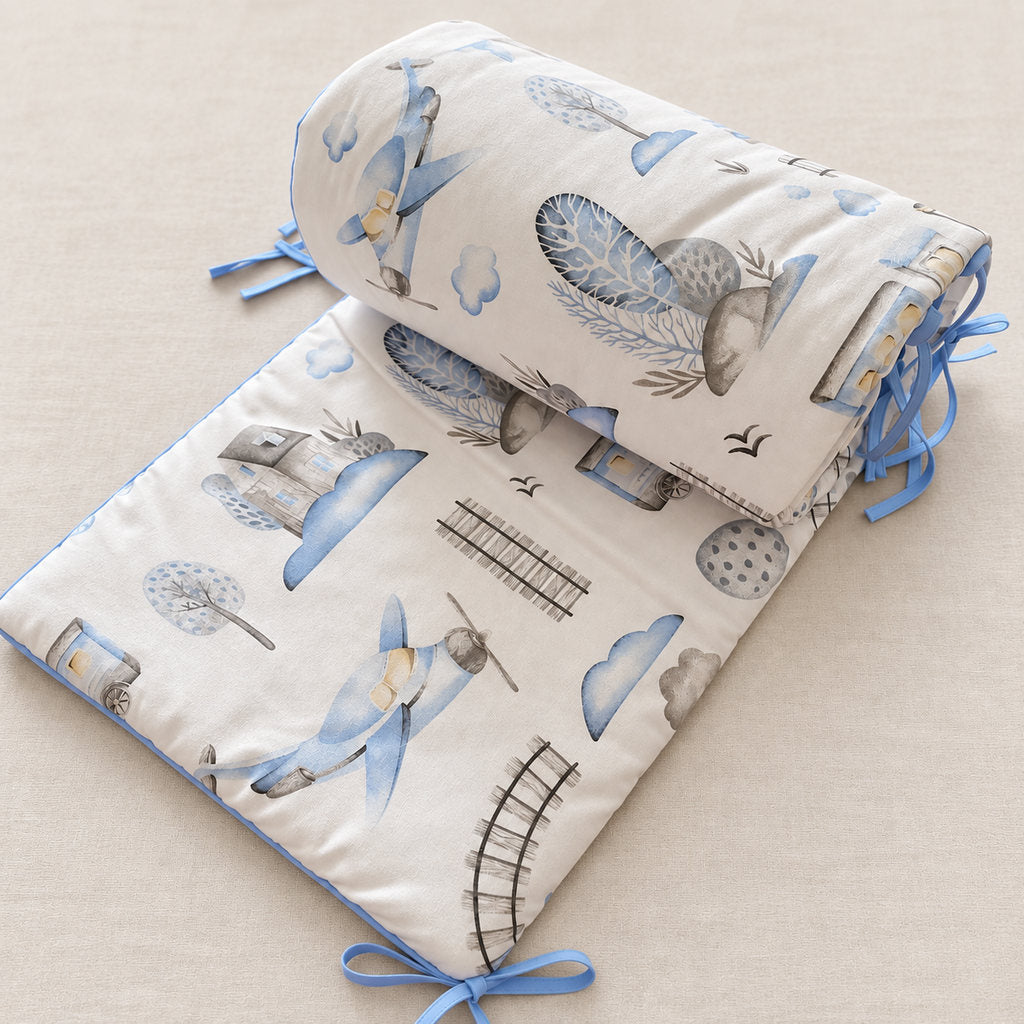blue train and aeroplane cot bed bumper with baby blue piping and ties
