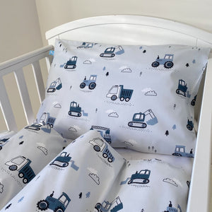 Crib bedding set with construction vehicle pattern on a white crib