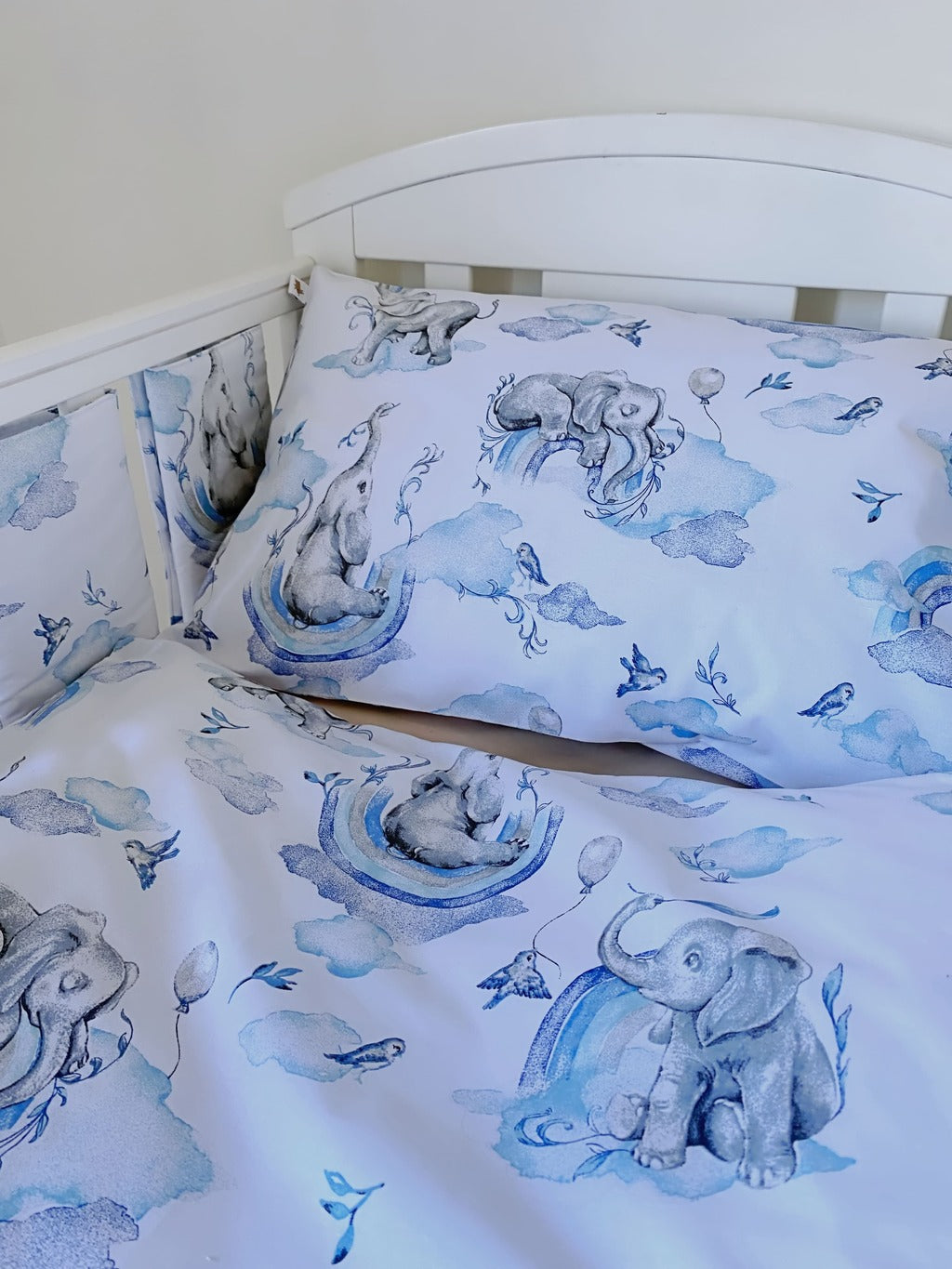 Boys’ safari nursery bedding set with blue elephant and rainbow print, featuring cot protector wraps

