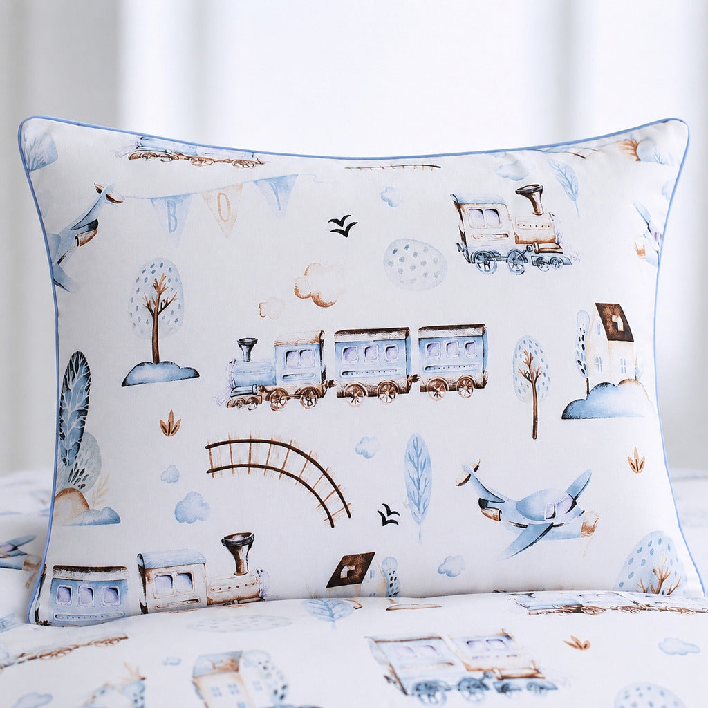 Close-up of beige cotton bedding with trains, aeroplanes, clouds and soft baby blue details. Fabricco