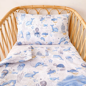 Under the sea bedding set in baby boy’s cot and toddler bedroom with ocean animal print.
