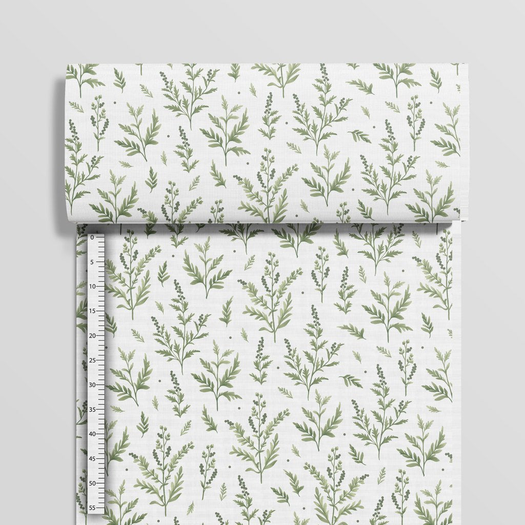Green botanical cotton fabric beside a centimetre ruler showing the size and spacing of the branches
