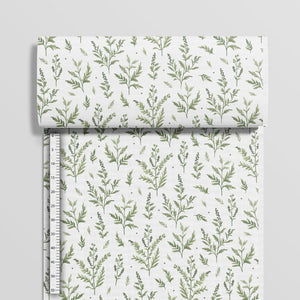 Green botanical cotton fabric beside a centimetre ruler showing the size and spacing of the branches