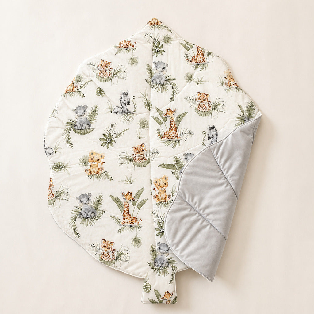 Close-up of jungle animals baby play mat with giraffe, tiger, hippo and green tropical leaves

