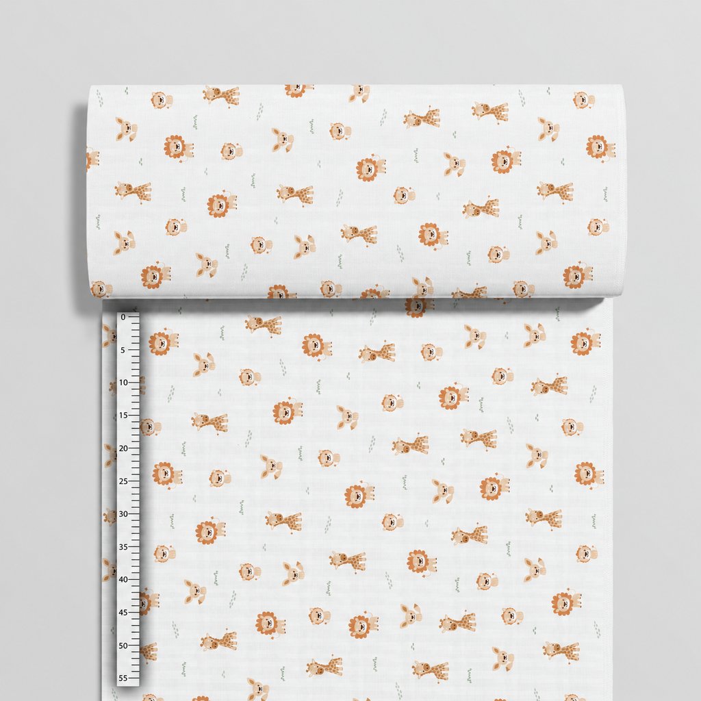 Safari animal cotton fabric beside a centimetre ruler, showing the small motifs and horizontal print direction