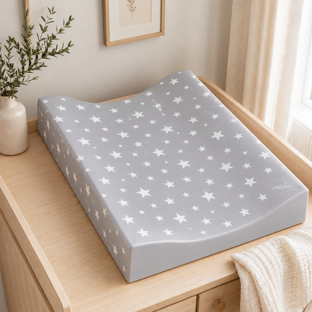 Milky Way grey baby changing mat with white stars and raised sides on a light oak nursery dresser