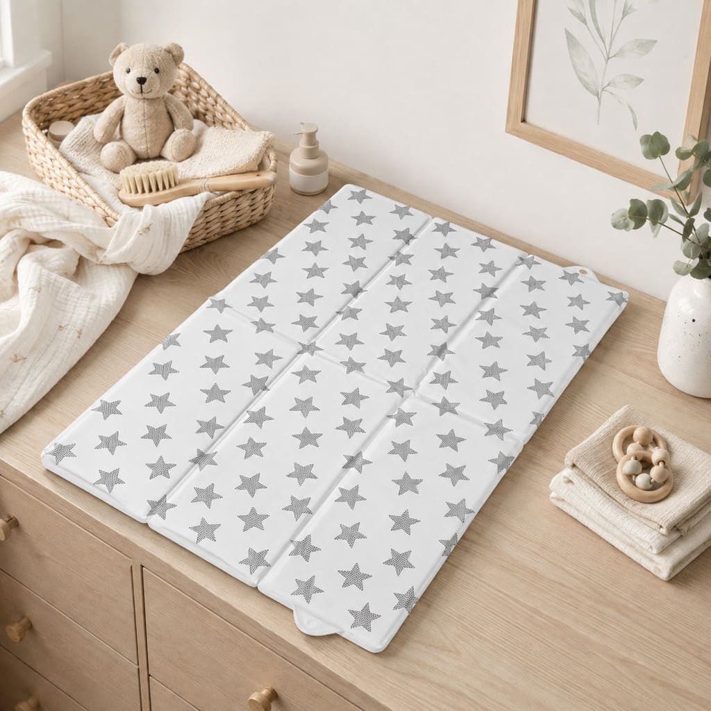 Monochrome Stars foldable baby travel changing mat beside a neutral changing bag