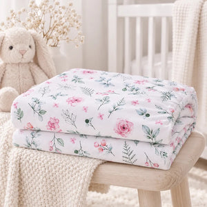 Folded pink botanical baby fitted sheet in 100% cotton with delicate flowers and sage green leaves