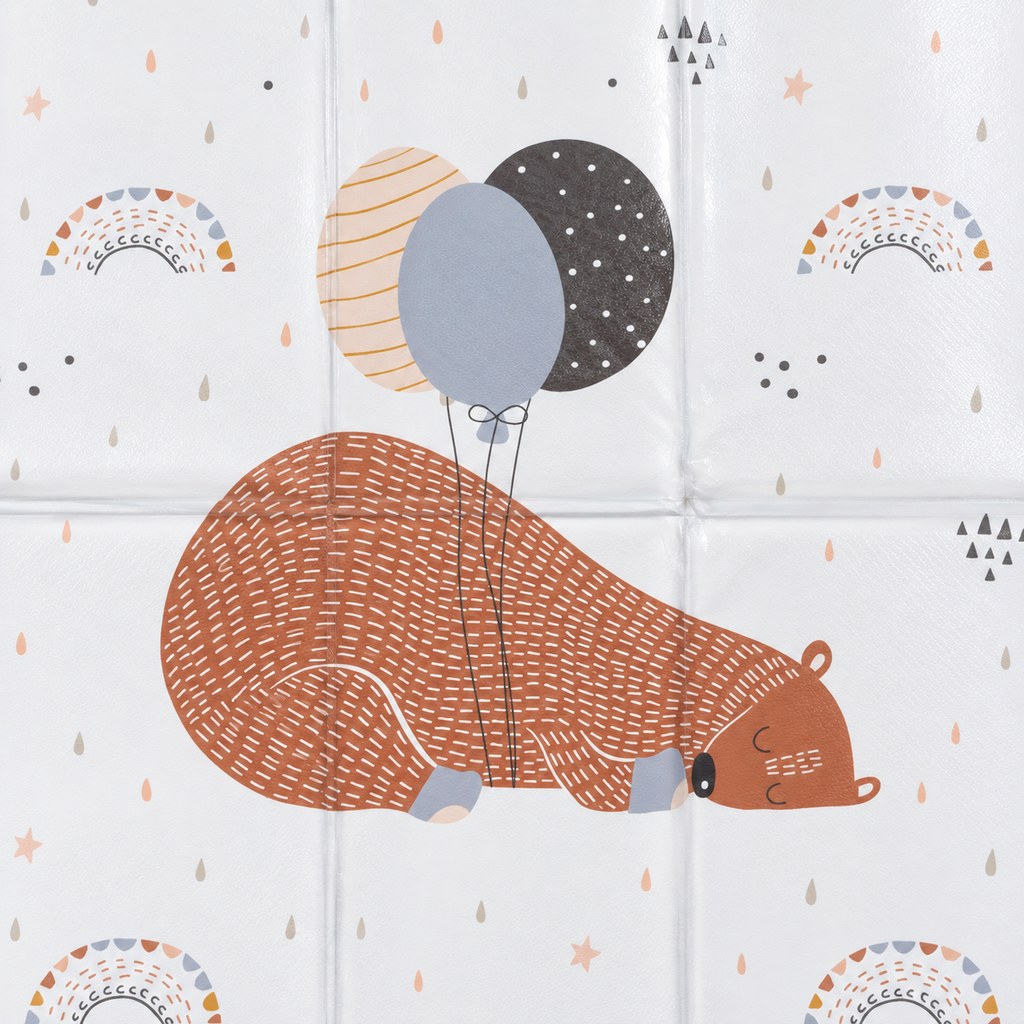 Close-up of the central sleeping bear and three balloons print on the white travel changing mat, showing its surface and folding seams.