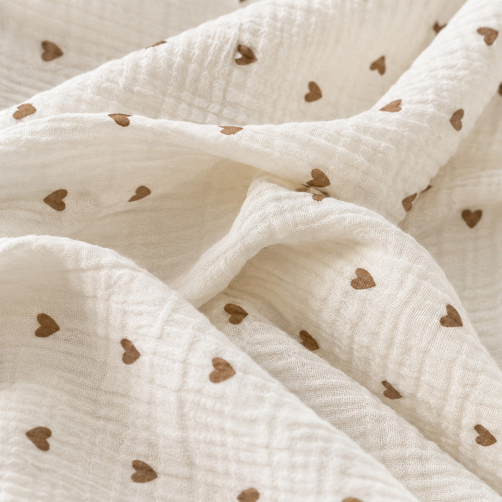 Soft crinkled muslin double gauze texture on a little brown hearts baby sheet, breathable cotton bedding for newborns, babies and toddlers.
