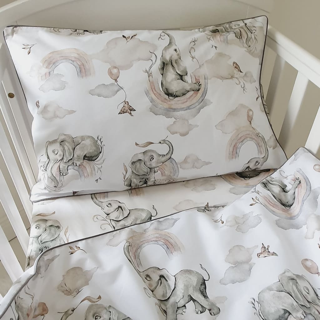 Soft_and_cozy_baby_bedding_set_featuring_playful_elephants_and_colorful_rainbows_in_gentle_natural_tones_perfect_for_a_nursery