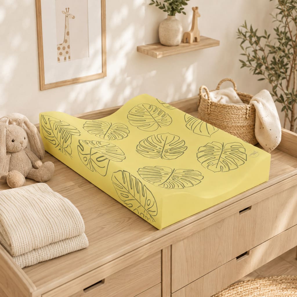 Soft ochre yellow leaf anti-roll baby changing mat in a Scandinavian-style nursery Fabricco