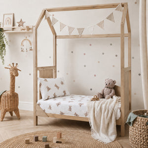 Neutral nursery with teddy bear muslin fitted cot sheet on a baby mattress, soft breathable cotton bedding for a Scandinavian style nursery.