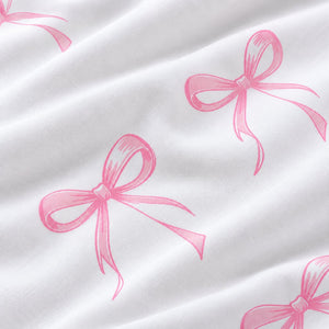 Close-up of white 100% cotton fabric with hand-drawn pink ribbon bows and a soft plain weave