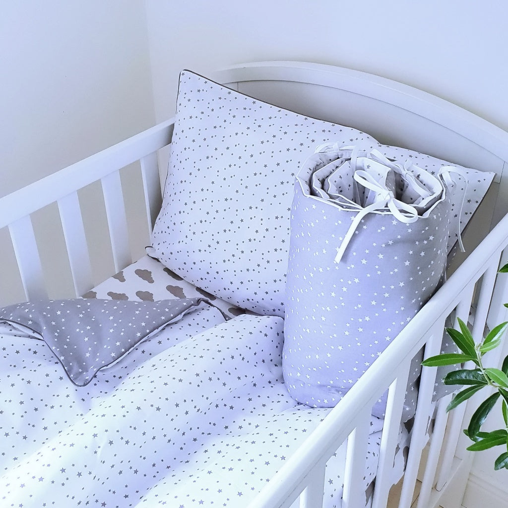 Tiny Stars Baby Bedding Set with Bumper is a lovely addition to any natural grey nursery, perfect for both girls and boys. Designed for cot beds measuring 70 x 140 cm, it features a reversible pattern with delicate white stars on grey and grey stars on the reverse.
