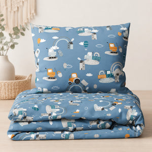 Close-up of blue cotton bedding with tractors, construction vehicles, hot air balloons and rainbow details.
