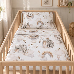 Watercolour elephant and rainbow cot bedding with grey piping, styled in a natural wooden cot in a neutral Scandinavian nursery.