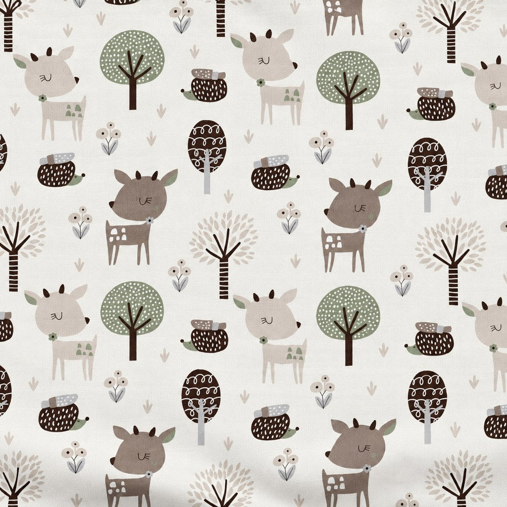 Close-up of beige and brown deer, hedgehogs, trees and berry sprigs on white cotton fabric