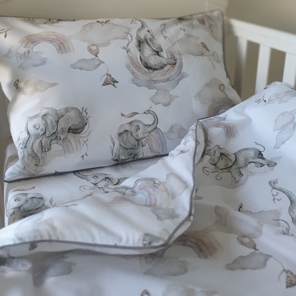Soft_and_cozy_baby_bedding_set_featuring_playful_elephants_and_colorful_rainbows_in_gentle_natural_tones_perfect_for_a_nursery