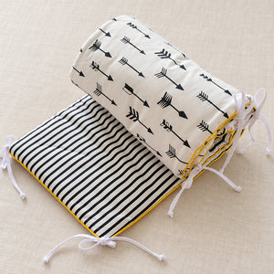 monochrome cot bed bumper showing black arrows, striped reverse and white ties